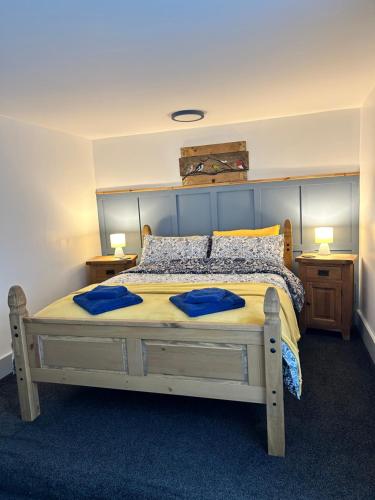 赖厄德Cadwgan House的一间卧室配有一张大床和两个蓝色枕头