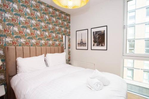 格拉斯哥Fantastic City Centre Flat的卧室配有白色床和花卉壁纸
