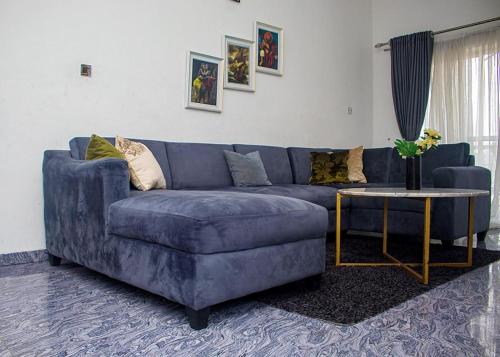 哈科特港Dew Shortlet Apartment的客厅配有一张蓝色的沙发,配有一张桌子