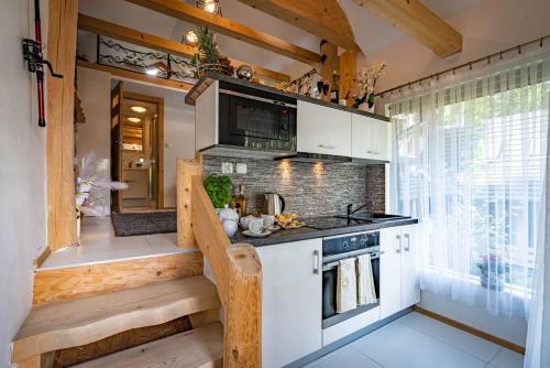 考斯赛力克Domki Sywor的一间厨房,厨房内有白色的橱柜和一个小房子里的楼梯
