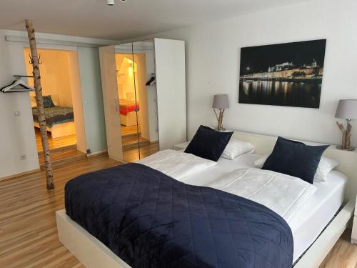 萨尔茨堡城市中心公寓的卧室配有带蓝色枕头的大型白色床