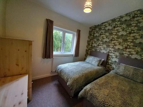 坎特伯雷Chapter Farm Cottages的一间卧室设有两张床和窗户。