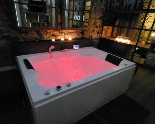 塞特港Balnéo Room, Loft Déco Authentique, Jacuzzi, Centre, Climatisation的客房内的热粉色浴缸配有蜡烛