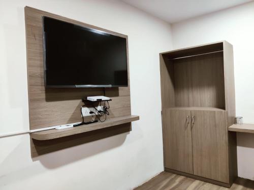 达曼HOTEL NEW RATNAKAR的一间配有平面电视的房间和墙上的自行车