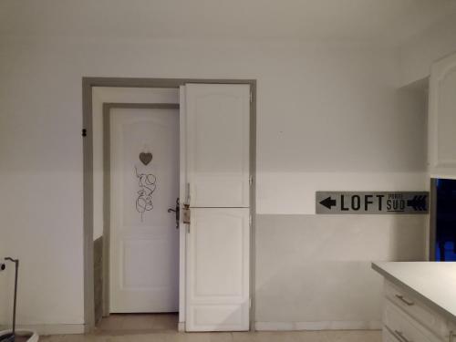 洛尔格Studio Églantine的白色墙壁房间的一扇开放式门