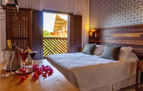 普拉亚多卡萨杜福特酒店的一间卧室配有一张床和一张鲜花桌子