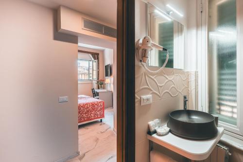 佛罗伦萨帕拉索本齐酒店的一间带水槽的浴室和一张桌子上的电话
