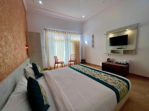 克久拉霍La Curcuma Luxury Homestay的一间酒店客房,配有一张大床和一台平面电视