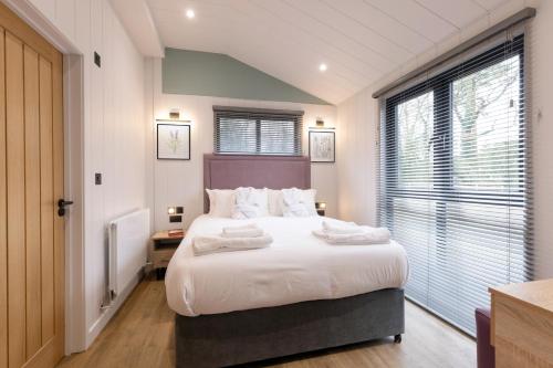 伍德斯托克Blenheim Palace Lodge Retreat的卧室配有一张带白色床单和枕头的大床。