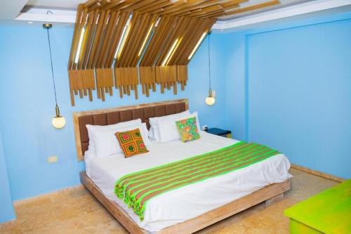 卡塔赫纳Coco Beach Hotel - Rooftop & Beach Club的一间卧室配有一张带蓝色墙壁的大床