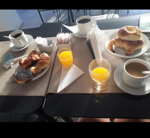 卡特里耶尔hotel el retorno的餐桌,包括早餐食品和橙汁