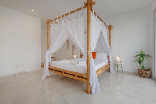 RibamarInspiration Villa的一间卧室配有一张四柱床和天蓬