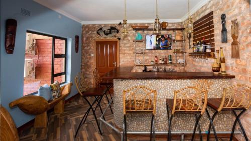 Nkhata BayKaweta Cottage的厨房设有酒吧、椅子和桌子