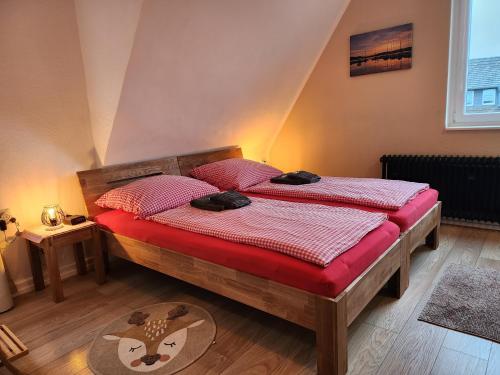 海姆巴赫Eifelblümchen的一间卧室配有两张单人床和红色床单