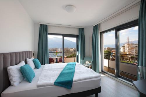 洛迦诺吉拉尼奥拉克酒店的酒店客房设有一张床和一个大窗户
