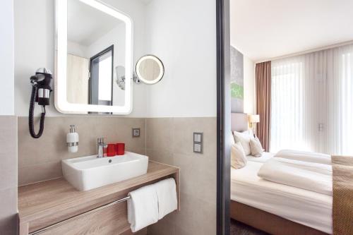 汉堡入住！博丁豪斯公寓式酒店的一间带水槽、床和镜子的浴室