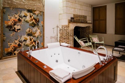 特鲁瓦小鸟家园Spa酒店的带壁炉的客房内设有浴缸。