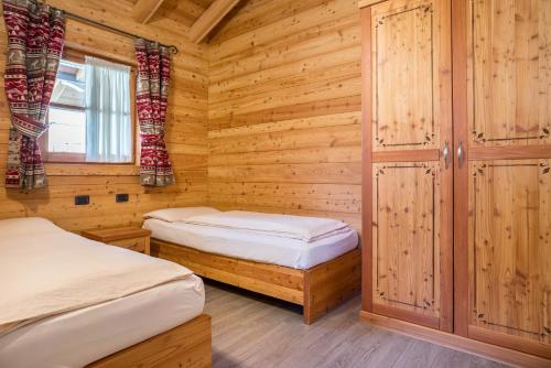 摩德纳迪-坎皮格里奥Chalet Camping Faè 1的小木屋设有两张床和窗户