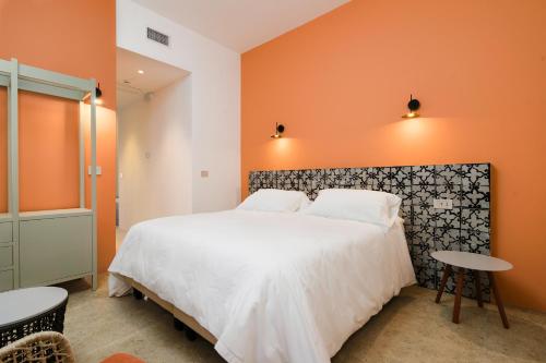 帕图Volito Rural Experience的一间卧室配有一张带橙色墙壁的大床