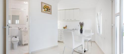 Donji HumacVilla Lilin San的白色的厨房配有白色的桌子和椅子