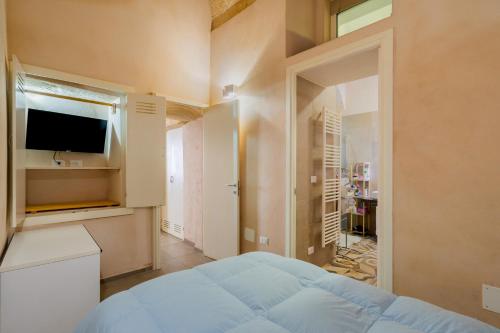 莱切Vico5的一间卧室配有一张床和一台平面电视