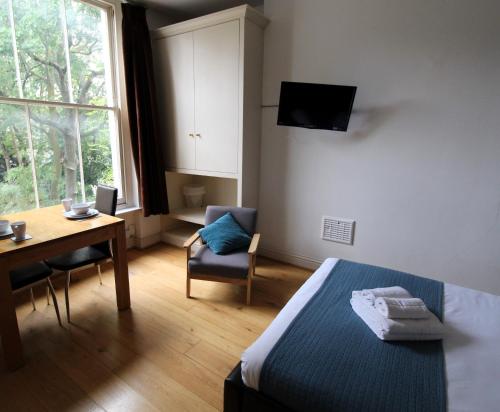 伦敦Longridge Road Apartments By Viridian Apartments的一间卧室配有一张床、一张桌子和一张书桌