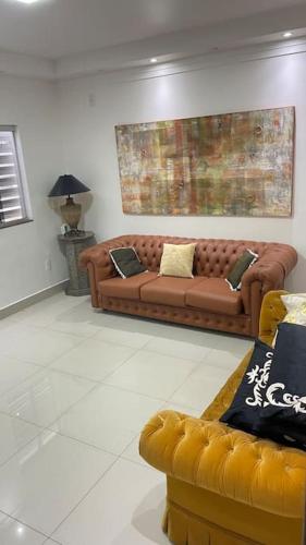 巴西利亚Casa próximo do aeroporto de Brasília的一间客厅,客厅内配有两张棕色沙发