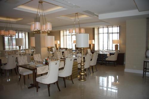 切博克萨雷伏尔加高级酒店的一间带桌子和白色椅子的用餐室