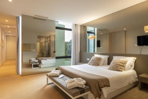蓬蒂-达巴尔卡Tempus Hotel & Spa的一间卧室设有一张大床和一个大镜子