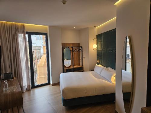巴达霍斯Hotel Las Tres Campanas的酒店客房设有一张床和一个大窗户