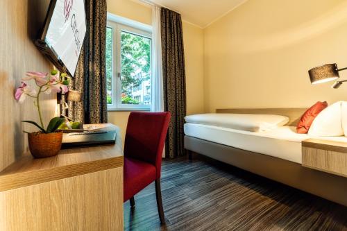 科隆CityClass Hotel am Heumarkt的配有一张床和一张书桌的酒店客房