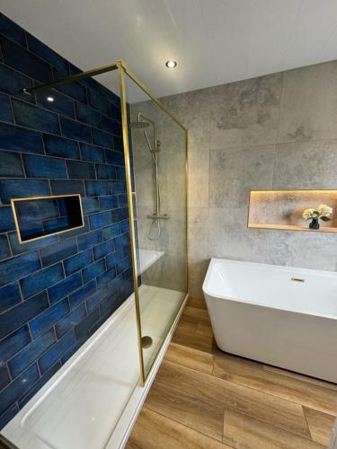 哈罗盖特Chequers Inn的带淋浴、浴缸和盥洗盆的浴室