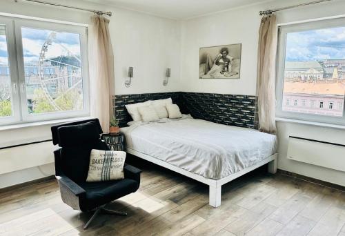 布达佩斯维斯塔1-2公寓的一间卧室配有一张床、一把椅子和窗户。