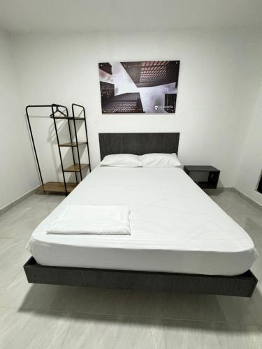 库库塔HOTEL LE QUINT的白色客房内的一张大白色床