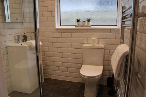 新米尔顿4 Bedroom Getaway New Forest的一间带卫生间、水槽和窗户的浴室