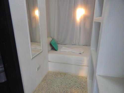 El YaquePOSADA RANCHO DELFIN的一间白色的小房间,配有床和镜子