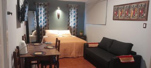 科尔多瓦Cerro de las Rosas的一间卧室配有一张床、一张桌子和一张沙发