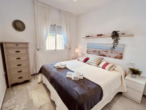 奇克拉纳－德拉弗龙特拉Apartamento Empul Costa Sancti Petri的一间卧室配有一张大床和毛巾