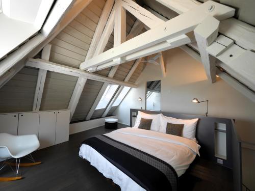 圣布莱斯L'Eau Forte - maison d'hôtes的阁楼上设有1间带1张大床的卧室