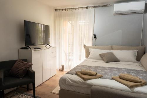 KriževciApartment City Cat的一间卧室设有一张大床和一台平面电视。