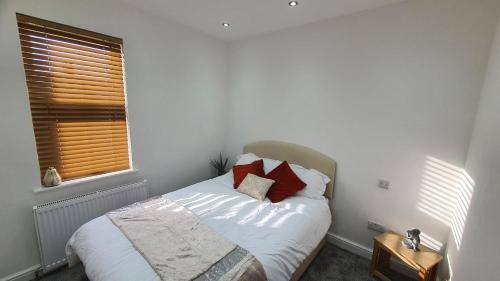 威灵堡Highfield House!的一间卧室配有带白色床单和红色枕头的床。