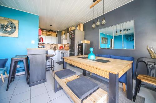 蒙彼利埃Grand T2 Montpellier Climatisation Terrasse Proche centre Ville et Plages的厨房以及带木桌和椅子的用餐室。