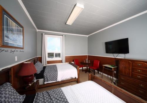 River of PondsGenevieve Bay Inn的一间卧室配有两张床和一台平面电视