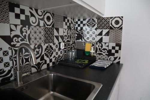 布拉涅沃Apartamenty Słoneczny Wieczór的厨房设有水槽和黑白瓷砖