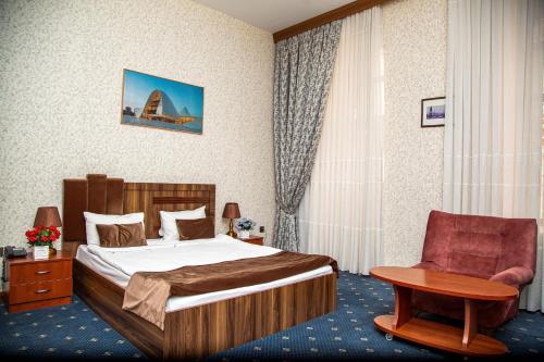 巴库Hotel & Bistro的配有一张床和一把椅子的酒店客房