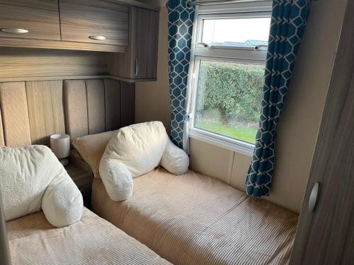 纽顿Luxury Romantic 2 Bedroom Caravan Trecco Bay的小房间设有床和窗户