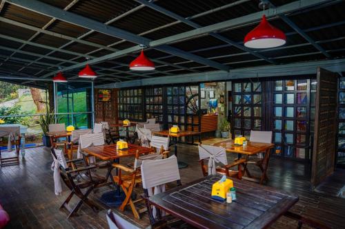 里奥内格罗FINCA HOTEL SANTO TOMAS REAL的餐厅设有木桌和椅子,并拥有红灯