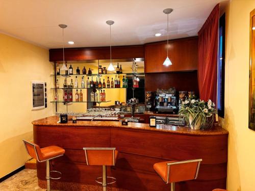 里米尼Ben Hur Rimini的餐厅内的酒吧配有两把椅子和柜台