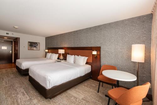 瓦勒多瓦尔多尔品质套房酒店的酒店客房带两张床和一张桌子以及椅子。