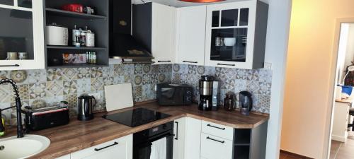 汉诺威Apartment.Abel-Misburg的厨房配有白色橱柜和木制台面